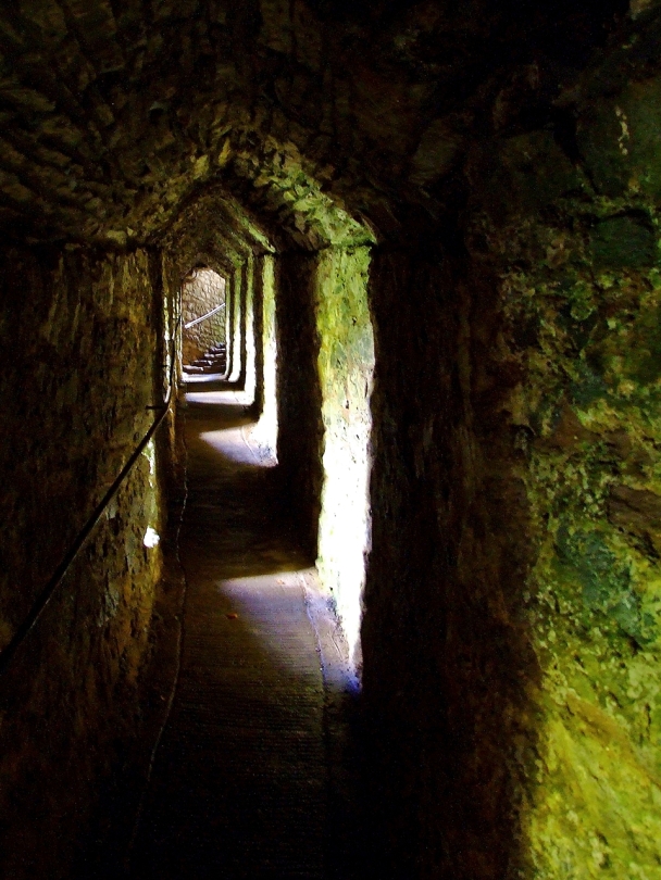 Wykuty w skale korytarz prowadzący do naturalnej jaskini pod zewnętrznym dziedzińcem zamku